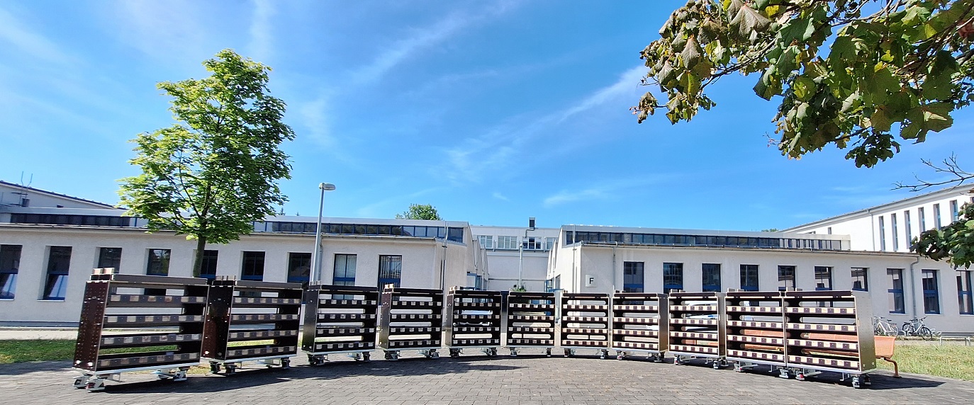 Rollwägen gefüllt mit Servern und Technik vor dem Gebäude der ligenium GmbH