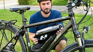 Mann tauscht E Bike Akku aus